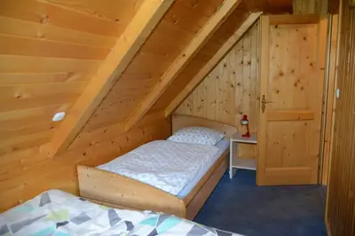 a bedroom with two beds in a attic at POČITNIŠKA HIŠA JURČEK POKLJUKA in Goreljek