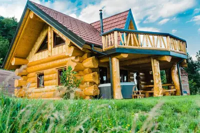 a log cabin with a wrap around deck at Forest Glade Cottage - Koča na jasi in Rečica ob Savinji
