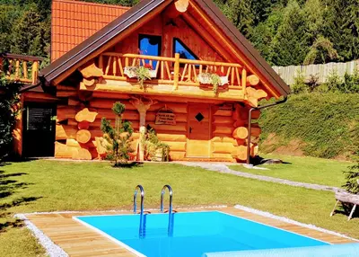 a log cabin with two faucets in front of it at Forest Glade Cottage - Koča na jasi in Rečica ob Savinji