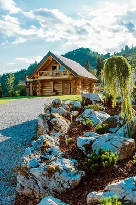 a garden in front of a log cabin at Forest Glade Cottage - Koča na jasi in Rečica ob Savinji