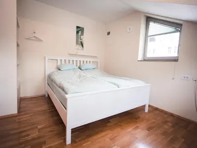 a bedroom with a white bed with blue pillows at Studio Kolman in Bled