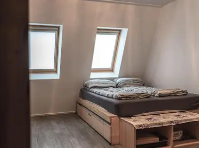 a bed in a room with two windows at Apartment Aly in Bovec