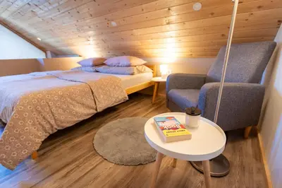 a bedroom with a bed and a chair and a table at Lovely Rustic House Pr' Čut in Žirovnica