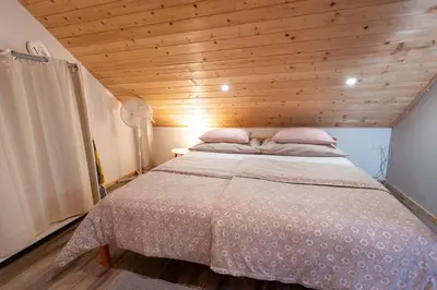a bed in a room with a wooden ceiling at Lovely Rustic House Pr' Čut in Žirovnica