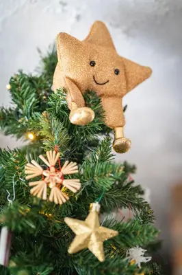 a christmas tree with a star ornament on it at Lovely Rustic House Pr' Čut in Žirovnica