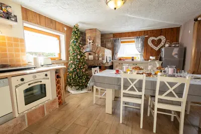 a kitchen with a table and a christmas tree in it at Lovely Rustic House Pr' Čut in Žirovnica