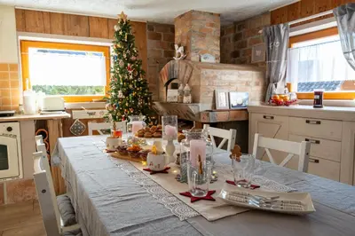 a kitchen with a table with a christmas tree at Lovely Rustic House Pr' Čut in Žirovnica
