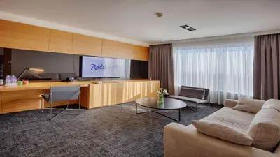 a living room with a couch and a tv at Radisson Blu Plaza Hotel Ljubljana in Ljubljana