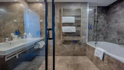 a bathroom with a tub and a sink and a shower at Radisson Blu Plaza Hotel Ljubljana in Ljubljana
