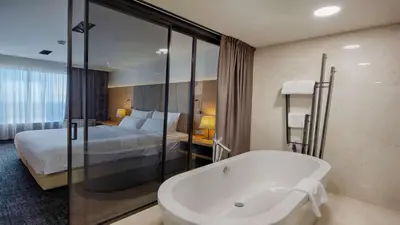 a bathroom with a bath tub and a bed at Radisson Blu Plaza Hotel Ljubljana in Ljubljana
