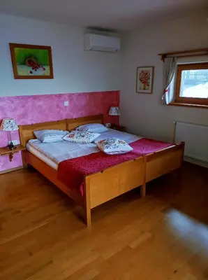 a bedroom with a large bed with a pink headboard at Relax Guest House Marjanca in Rogaška Slatina