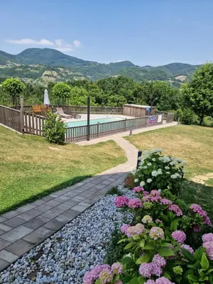 a garden with flowers and a swimming pool at Relax Guest House Marjanca in Rogaška Slatina