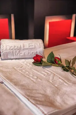 a white bed with two roses on top of it at Hotel Lent in Maribor