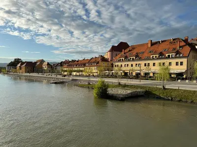 a river with houses and buildings next to a city at Hotel Lent in Maribor