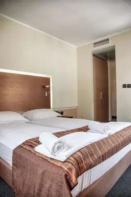 a bedroom with a large bed with towels on it at Hotel Lent in Maribor