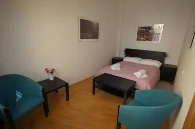 a small bedroom with a bed and two chairs at BIT apartments in Ljubljana