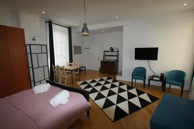 a room with a bed and a table and a tv at BIT apartments in Ljubljana