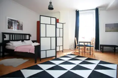 a bedroom with a bed and a black and white checkered floor at BIT apartments in Ljubljana