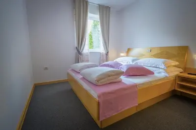 a bedroom with a bed with pillows and a window at Villa Nena in Kranjska Gora