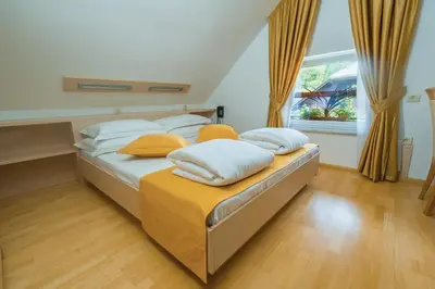 a bedroom with two beds with yellow pillows and a window at Villa Nena in Kranjska Gora