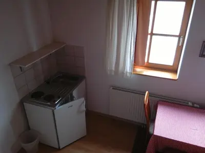 a small kitchen with a stove and a window at Tourist Farm Joannes in Maribor