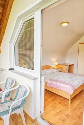 a bedroom with a bed and a window at Apartments Kovačič in Bohinj