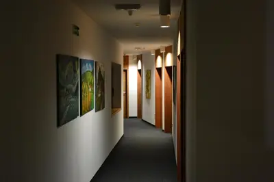 a hallway with paintings on the walls of a building at Hotel Rakar in Trebnje