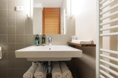 a bathroom with a sink and a bunch of towels at Hotel Rakar in Trebnje