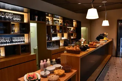 a restaurant with a bar with wine glasses at Hotel Rakar in Trebnje