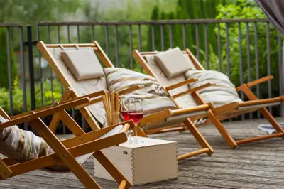 two chairs and a glass of wine on a deck at Hotel Rakar in Trebnje