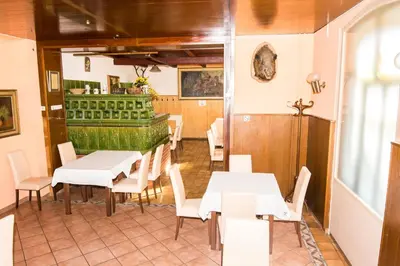 a restaurant with white tables and chairs and a bar at Guesthouse Jersin in Logatec