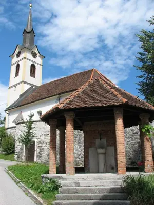 a church with a clock tower on top of it at Guesthouse Jersin in Logatec