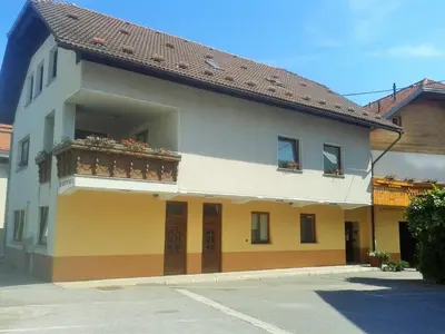 a building with a balcony with flowers on it at Guesthouse Jersin in Logatec