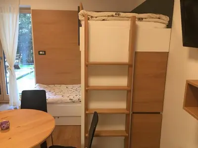 a small room with a bunk bed and a table at Apartma Rogla - Gaber 98 in Resnik