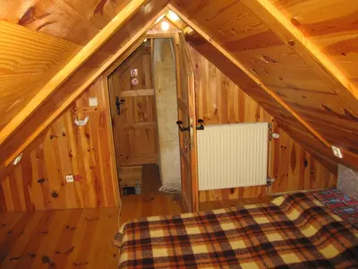 a attic room with a bed in a wooden cabin at Holiday Home Carovina in Paradiž