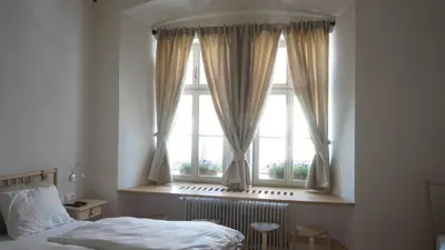 a bedroom with a bed and a window with curtains at Sobe Proštija in Ptuj