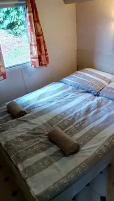 a bed sitting in a room with a window at Samson mobile house in Bled
