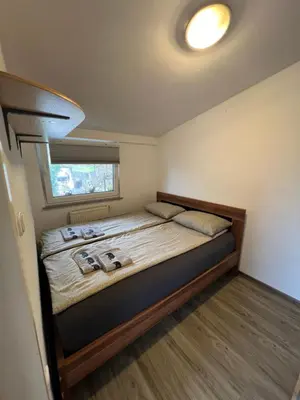 a small bedroom with a bed with a window at apartma Golovec in Ljubljana