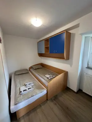 a small room with a bed and a cabinet at apartma Golovec in Ljubljana