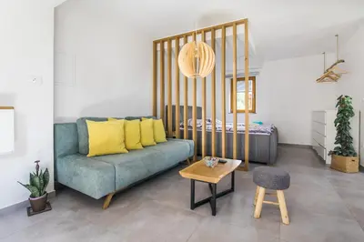 a living room with a blue couch with yellow pillows at Pr' Petrču in Tolmin