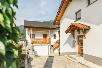 a white house with a gate and a balcony at Pr' Petrču in Tolmin