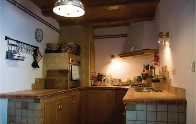 a kitchen with wooden cabinets and a counter top at 4 Bedroom Amazing Home In Vrhnika in Vrhnika