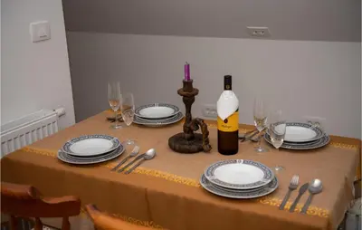 a table with plates and glasses and a bottle of wine at 4 Bedroom Amazing Home In Vrhnika in Vrhnika