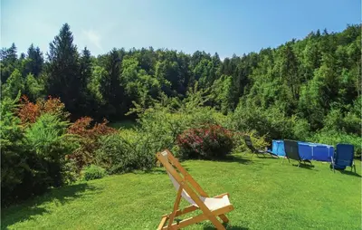 a wooden bench sitting in the grass in a field at 4 Bedroom Amazing Home In Vrhnika in Vrhnika