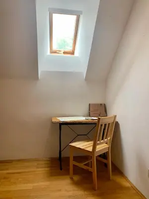 a table with a chair in a room with a window at Apartma Pr'Toman in Kamna Gorica