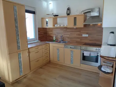 a kitchen with wooden cabinets and a sink at Apartment Japka in Bovec