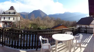 a white table and chairs on a balcony with mountains at Apartment Japka in Bovec