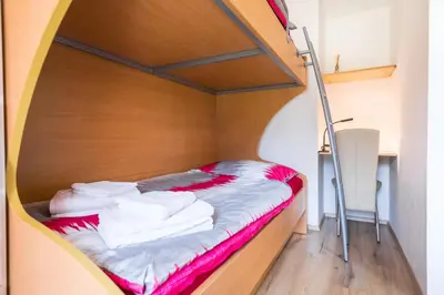 a bed in a small room with red and white towels at Apartment Japka in Bovec