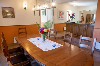 a dining room table with a vase of flowers on it at Villa Anton - The Old Dairy in Hrušica