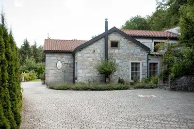 a stone house with a brick driveway in front of it at Villa Anton - The Old Dairy in Hrušica